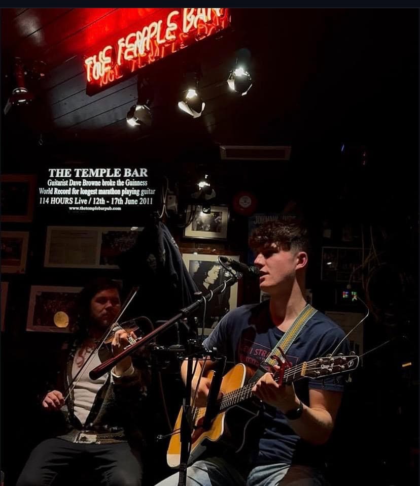 Tom Forkin singing with a fiddle player at The Temple Bar